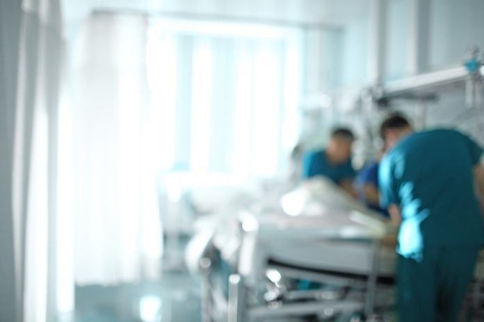 Medical,Doctor,Team,At,The,Bedside,Of,Patient,,Unfocused,Background.